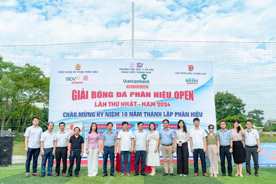 A group of people standing in front of a sign

Description automatically generated